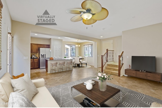 living room featuring ceiling fan with notable chandelier