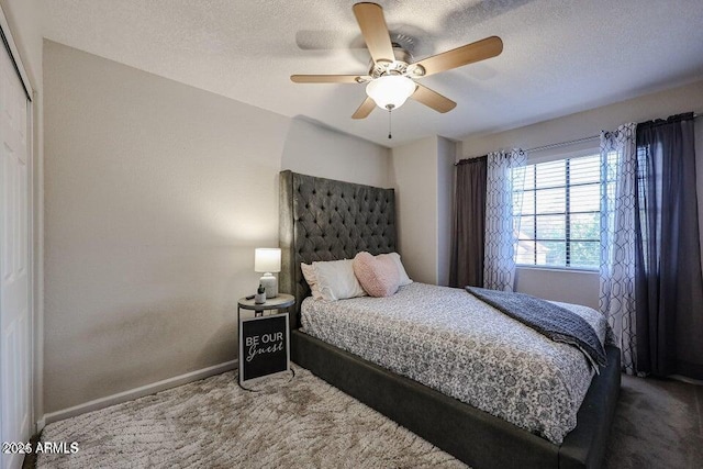 carpeted bedroom with ceiling fan and a textured ceiling