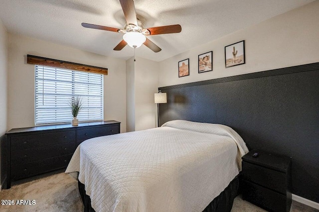 carpeted bedroom featuring ceiling fan and a textured ceiling