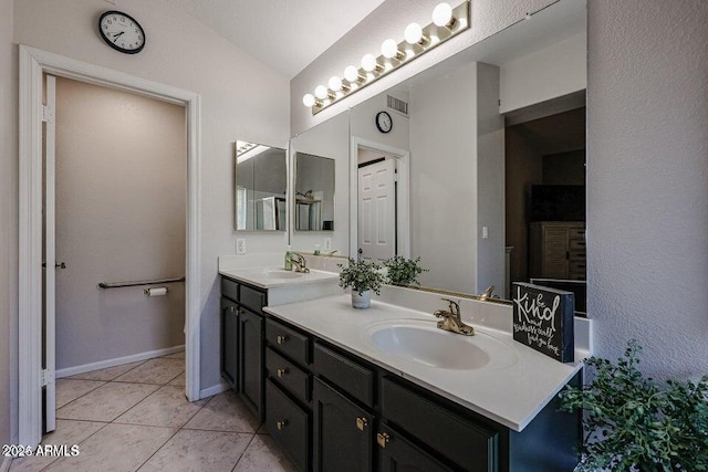 bathroom featuring tile patterned floors, vanity, and vaulted ceiling