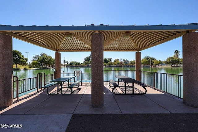 view of dock featuring a water view, a gazebo, and a patio area