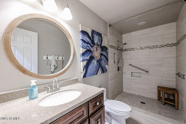 bathroom with tiled shower, toilet, and vanity