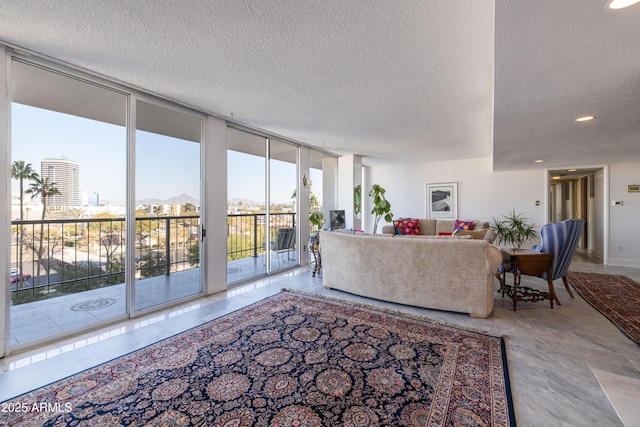 living room featuring a textured ceiling and a wall of windows