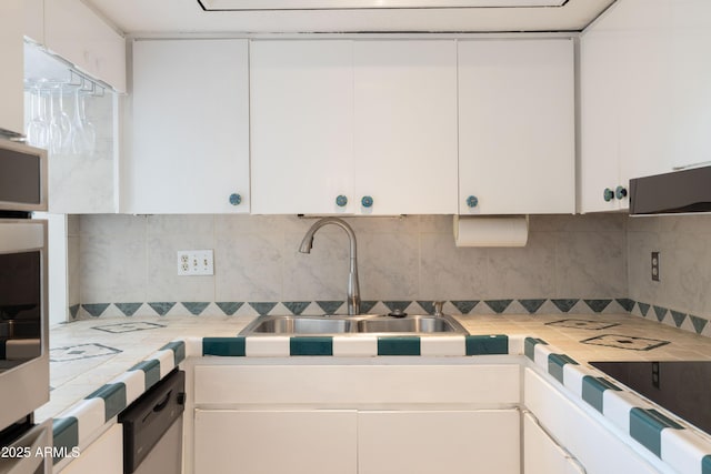 kitchen with dishwasher, sink, white cabinets, and decorative backsplash