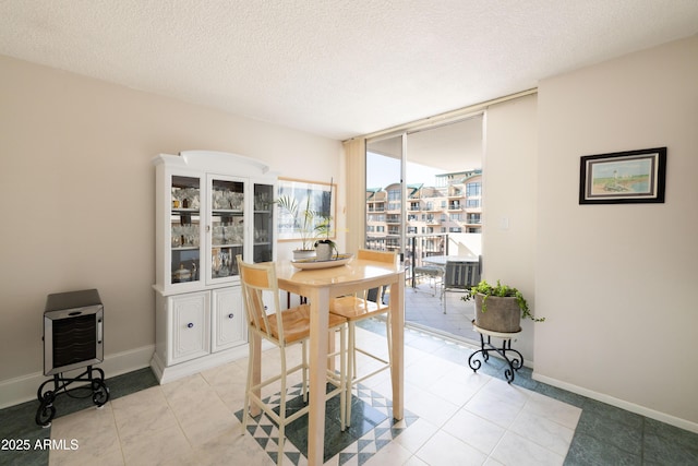 dining room with light tile patterned flooring, a wall of windows, a textured ceiling, and heating unit