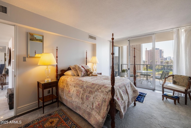 carpeted bedroom featuring a textured ceiling, access to exterior, and a wall of windows