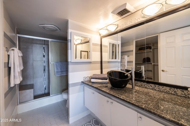 bathroom with vanity, toilet, and a shower with door