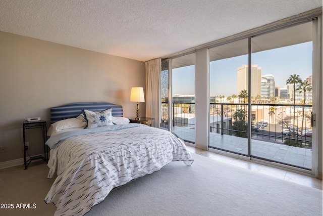 carpeted bedroom featuring access to exterior, floor to ceiling windows, and a textured ceiling