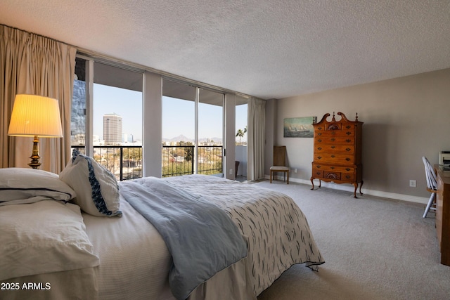 bedroom with expansive windows, carpet flooring, access to exterior, and a textured ceiling