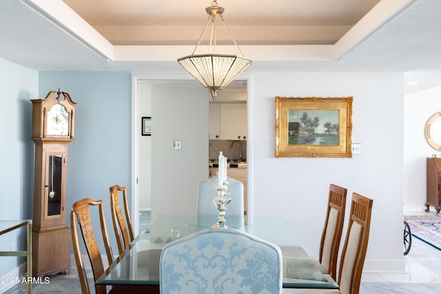 dining room featuring a raised ceiling and sink