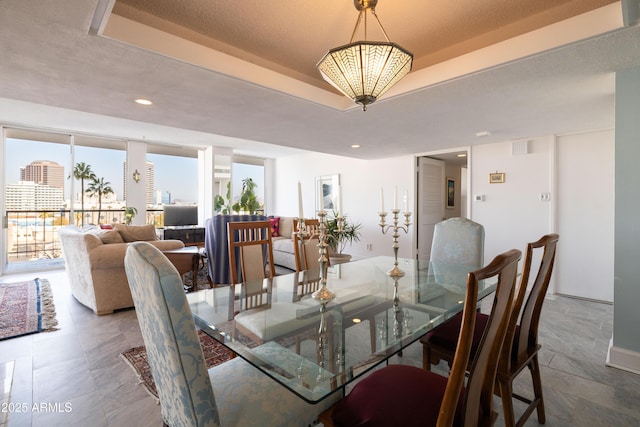 dining room featuring a tray ceiling and a textured ceiling