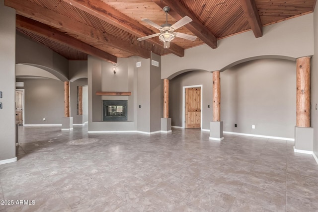 5347 E 10th Ave, Apache Junction, AZ 85119 - unfurnished living room with arched walkways, a wooden ceiling with exposed beams, ornate columns, a ceiling fan, and a multi sided fireplace