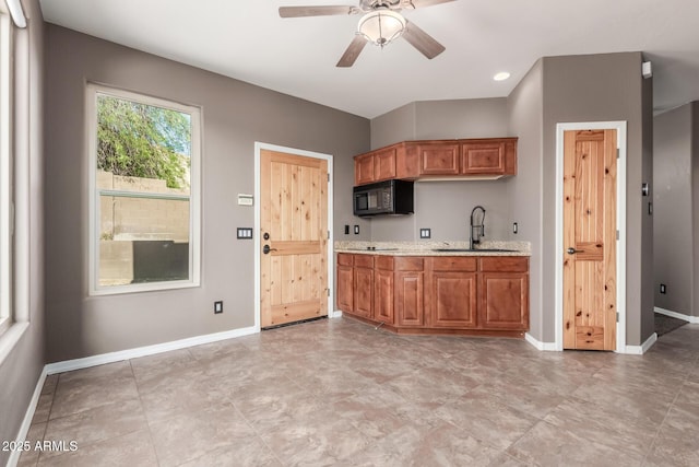 5347 E 10th Ave, Apache Junction, AZ 85119 - kitchen with black microwave, a ceiling fan, brown cabinets, light stone counters, and recessed lighting