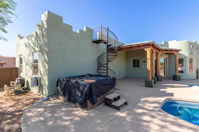 5347 E 10th Ave, Apache Junction, AZ 85119 - back of house featuring stairs, a hot tub, a patio area, and stucco siding