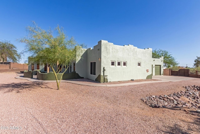 5347 E 10th Ave, Apache Junction, AZ 85119 - rear view of house with a garage, driveway, stucco siding, and a gate