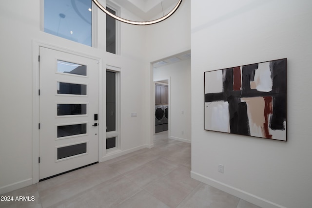 foyer featuring separate washer and dryer and a towering ceiling