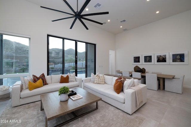 living room featuring a mountain view, a towering ceiling, and ceiling fan