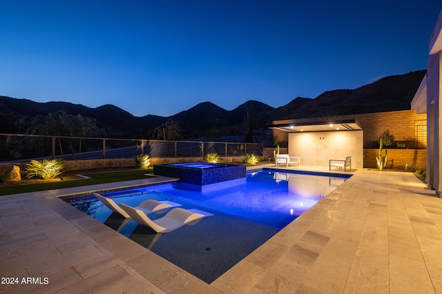 view of swimming pool featuring a mountain view, an in ground hot tub, and a patio area