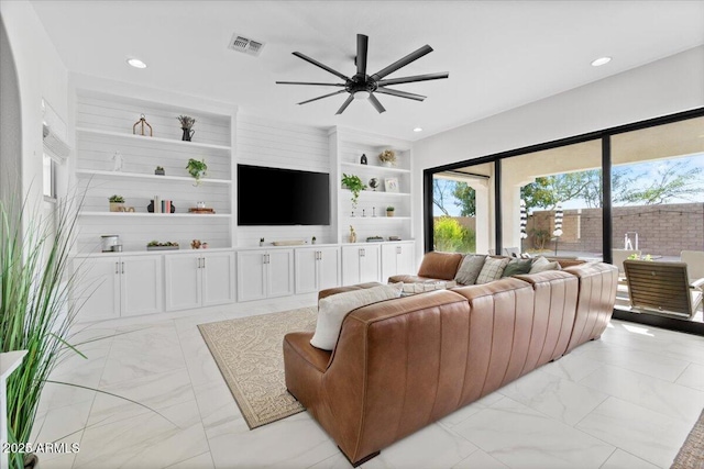 living room with ceiling fan and built in shelves