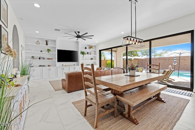 dining space with ceiling fan and built in shelves