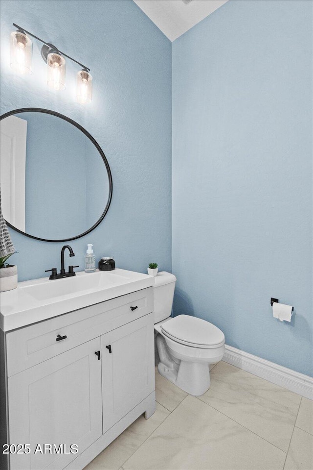 bathroom with toilet, tile patterned floors, and vanity