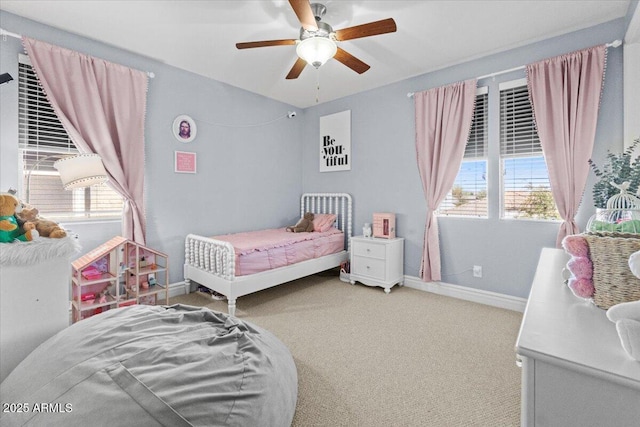 carpeted bedroom featuring ceiling fan and multiple windows