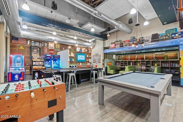 playroom with light hardwood / wood-style floors, pool table, and a high ceiling