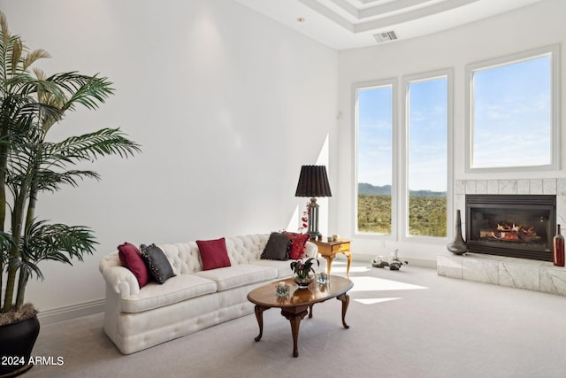 carpeted living room featuring a tile fireplace