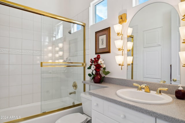 full bathroom featuring vanity, toilet, and enclosed tub / shower combo