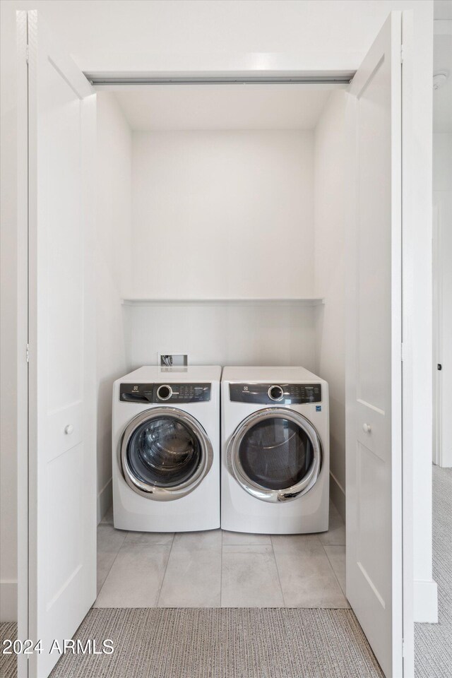 laundry room featuring light tile patterned flooring and washer and dryer