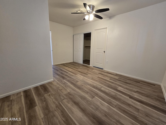 unfurnished bedroom with ceiling fan, dark hardwood / wood-style flooring, and a closet