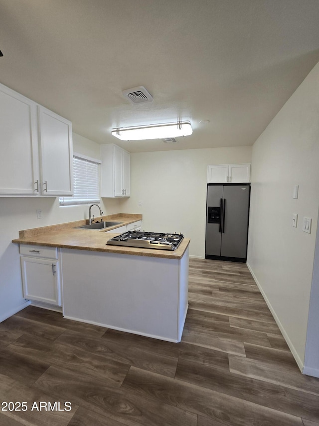 kitchen with sink, white cabinets, dark wood-type flooring, and appliances with stainless steel finishes