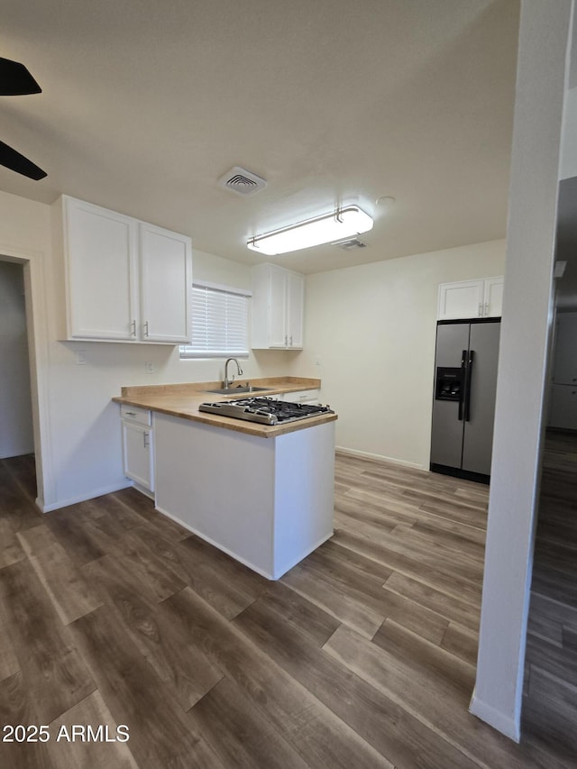 kitchen featuring stainless steel appliances, ceiling fan, sink, hardwood / wood-style floors, and white cabinetry