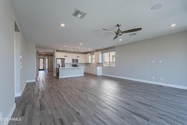 unfurnished living room featuring ceiling fan, dark wood finished floors, baseboards, and recessed lighting