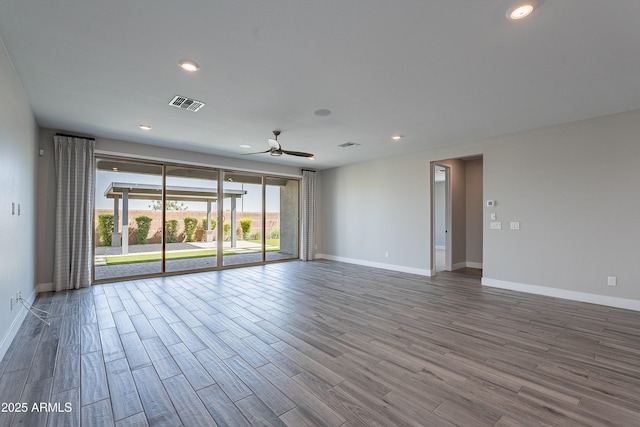empty room with a ceiling fan, baseboards, wood finished floors, and recessed lighting