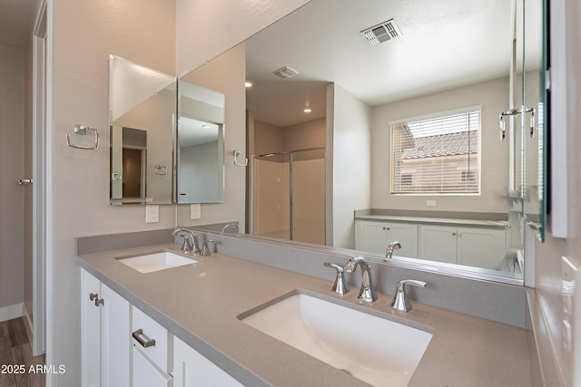 full bathroom with a shower with shower door and double vanity