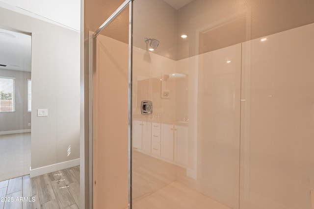 bathroom featuring a shower, wood finished floors, and baseboards