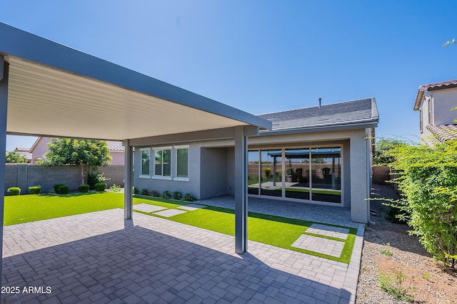 rear view of property featuring stucco siding and a patio area