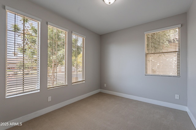 carpeted spare room with baseboards