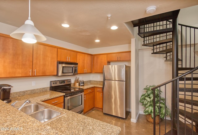 kitchen featuring appliances with stainless steel finishes, sink, and hanging light fixtures