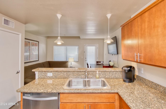 kitchen with decorative light fixtures, sink, stainless steel dishwasher, and kitchen peninsula