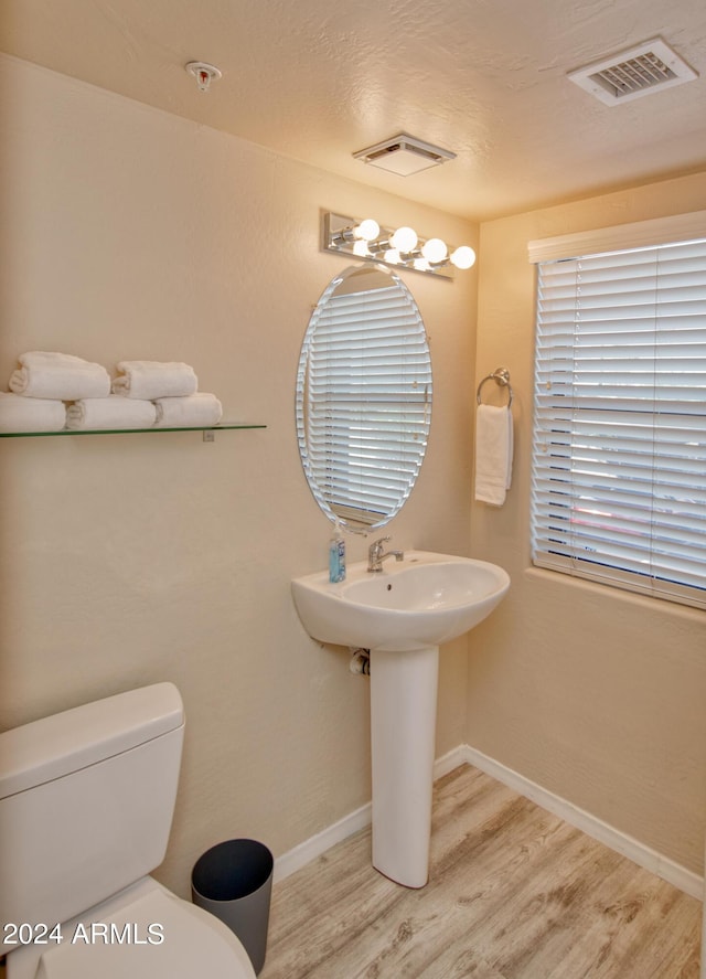 bathroom featuring hardwood / wood-style flooring and toilet