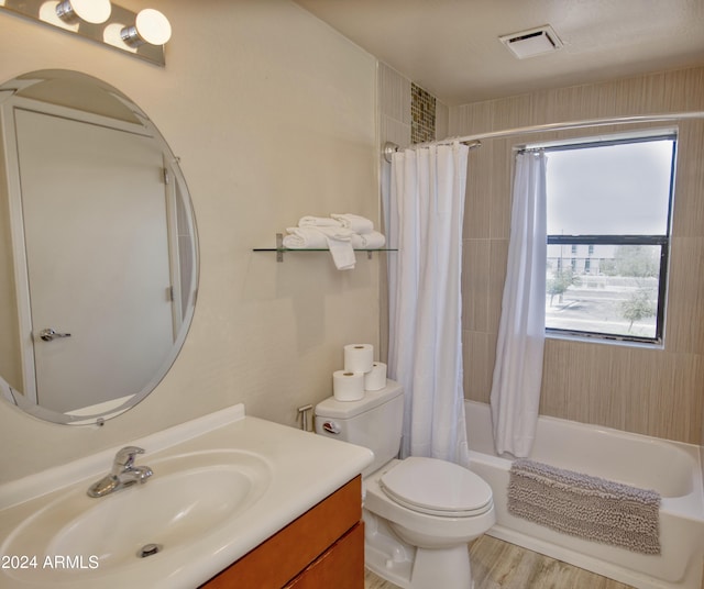 full bathroom featuring vanity, wood-type flooring, shower / bathtub combination with curtain, and toilet