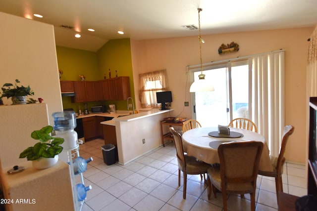 tiled dining room with lofted ceiling and sink