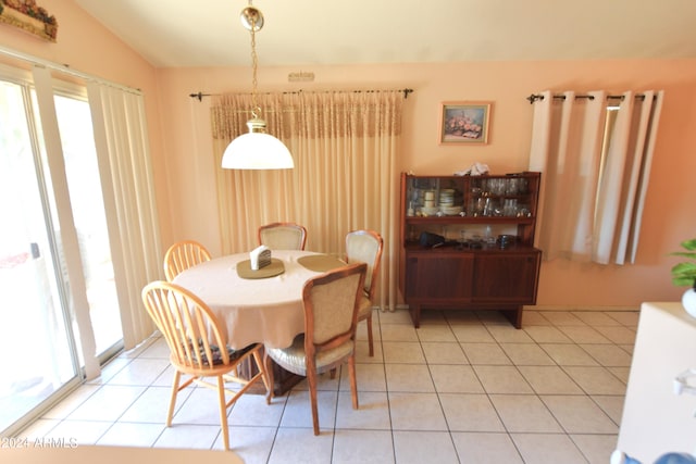 dining room with vaulted ceiling and light tile patterned floors