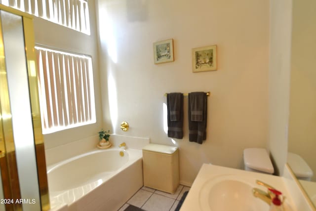 bathroom with toilet, a washtub, sink, and tile patterned floors