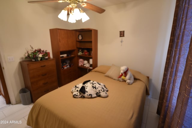 tiled bedroom featuring ceiling fan