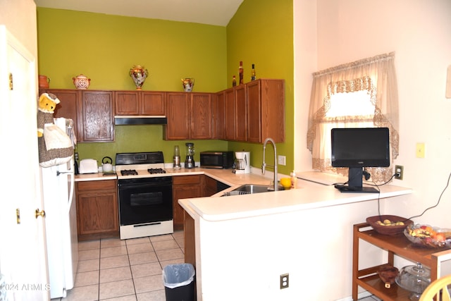 kitchen with light tile patterned flooring, sink, kitchen peninsula, white appliances, and vaulted ceiling