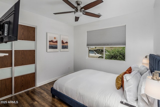 bedroom with ceiling fan, wood finished floors, visible vents, and baseboards