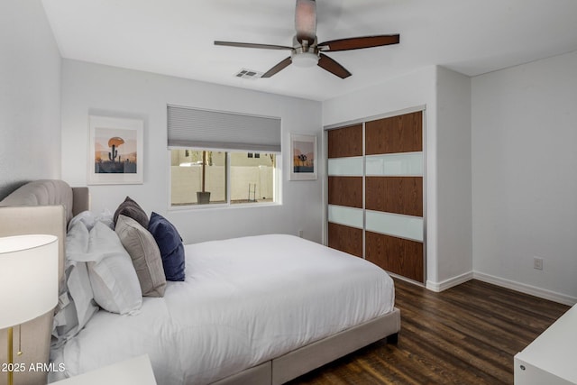 bedroom with a closet, visible vents, ceiling fan, wood finished floors, and baseboards